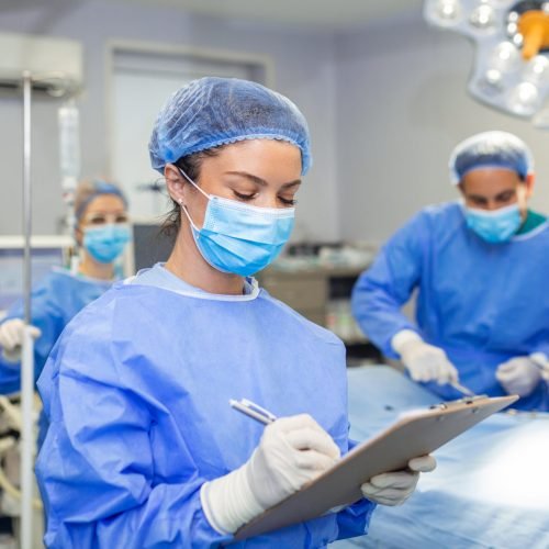 Surgeon writing on clipboard in operation room